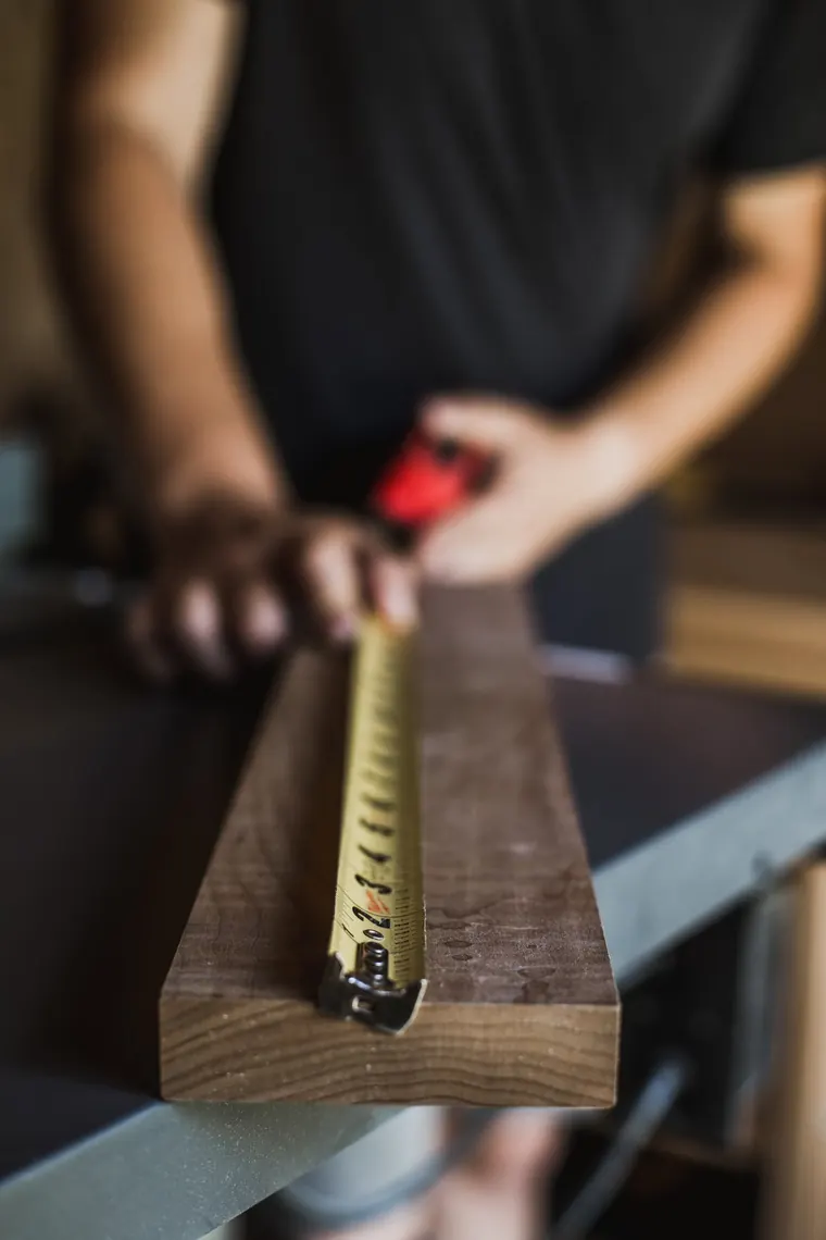 Carpenter measuring a wood component carefully before cutting
