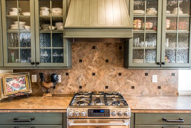 Detailed kitchen cabinet hood, upper crown trim, and glazed cabinet doors